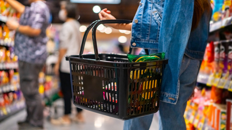 woman in carrying grocery store basket while shopping