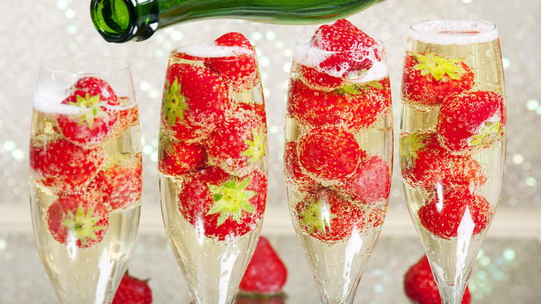 pouring Champagne in glasses of strawberries