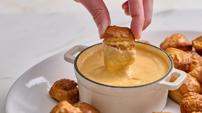 dipping pretzel into beer cheese