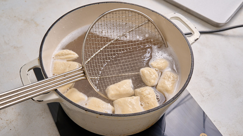 dunking pieces of dough into the water