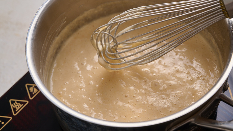whisking beer and milk in pot