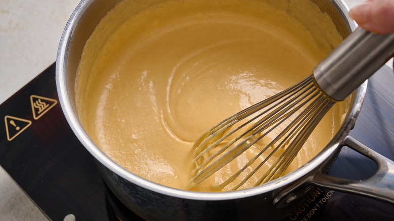 whisking cheeses into pot