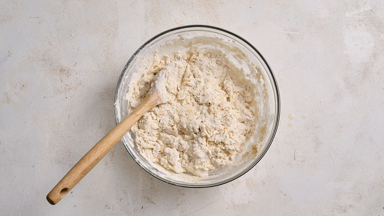 kneading the dough in a bowl