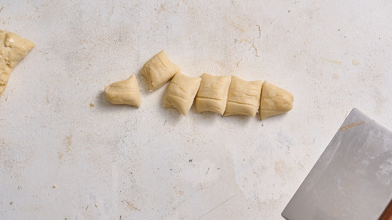 slicing pieces of dough into bite sized pieces