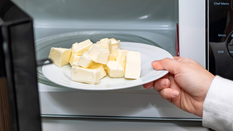 person putting butter into a microwave