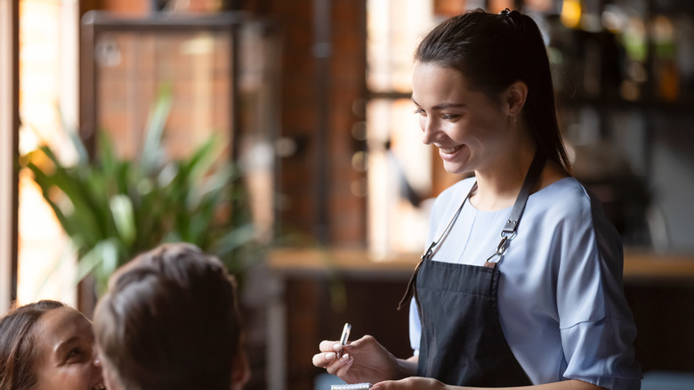 Restaurant server speaking to patrons