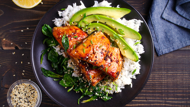 Overhead view of salmon, rice, and greens on a plate