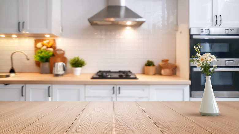view of kitchen island with lit countertops in background