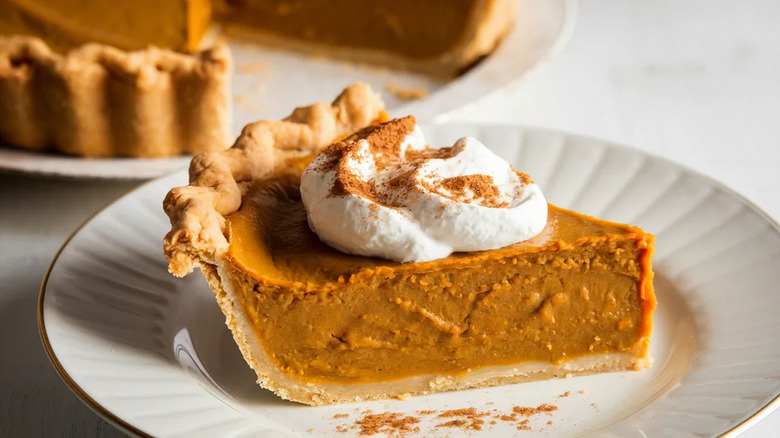 Slice of pumpkin pie with whipped cream