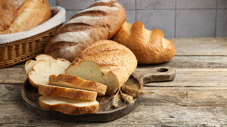 Different types of bread loaves sliced on a cutting board