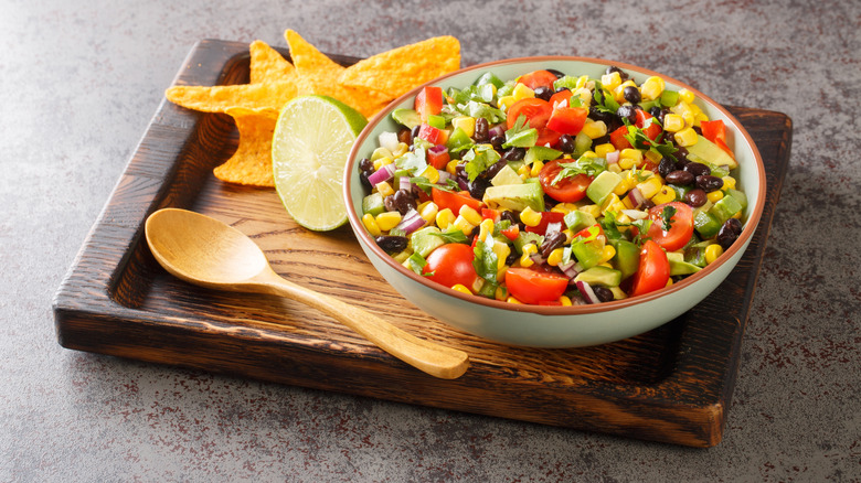 Cowboy caviar dip in bowl on wooden serving board