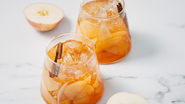 Two glasses of of apple sangria beside apple