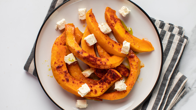 Roasted and spiced squash with cubes of feta on a plate