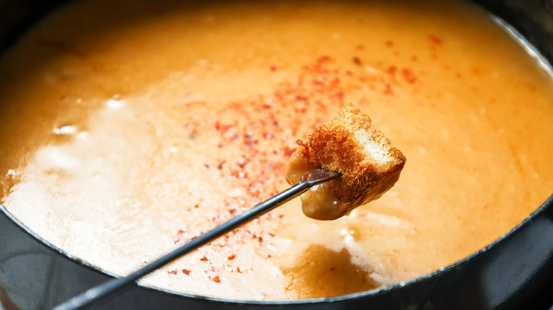 Dipping toasted bread into fondue