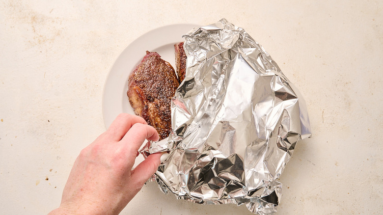 tenting steaks on a plate