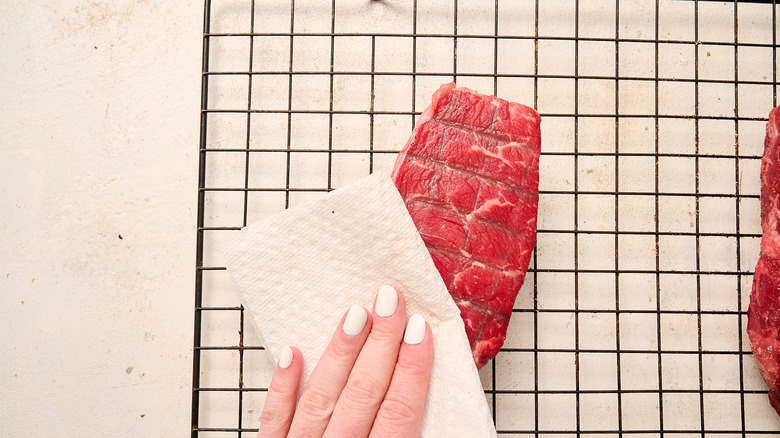 patting steaks dry with paper towel