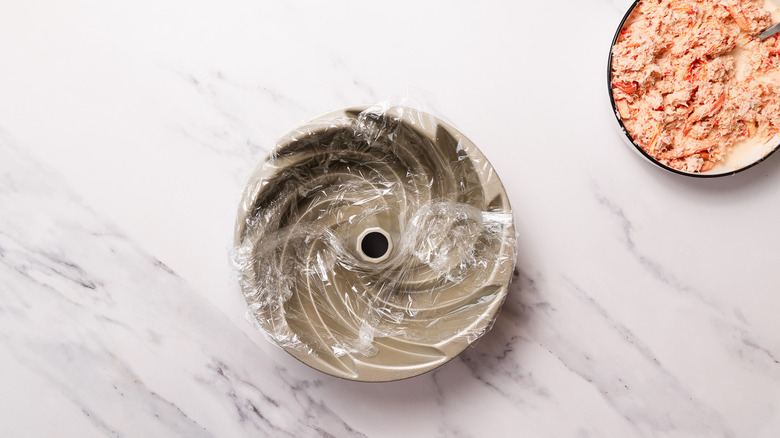 plastic wrapped bundt cake pan and spicy crab mix