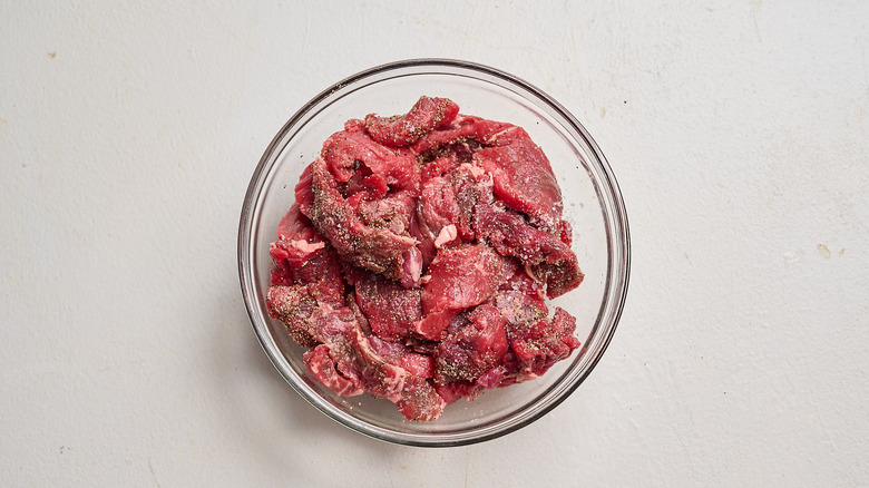 seasoning steak in a bowl