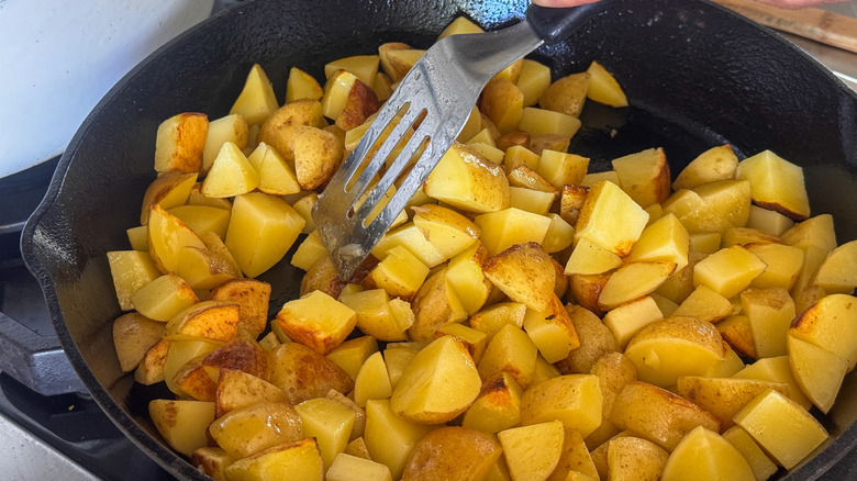 spatula in pan with potatoes