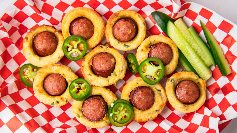 Mini corn dogs in basket with fresh cucumbers and jalapenos.