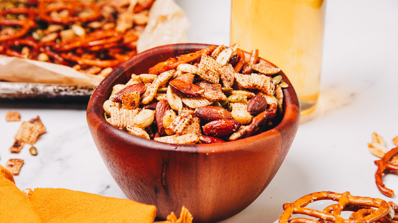Bowl of spicy savory snack mix near beer.