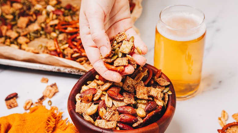 Hand picking up a handful from the spicy savory snack mix.