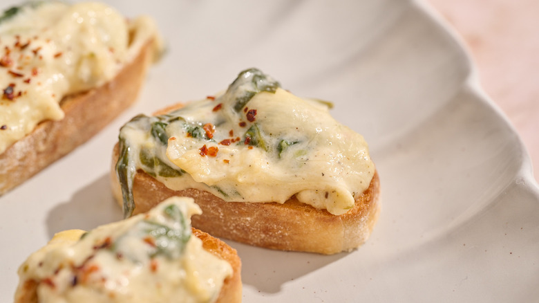 spinach and artichoke dip crostini on a platter
