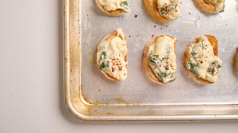 topping crostini with red pepper flakes