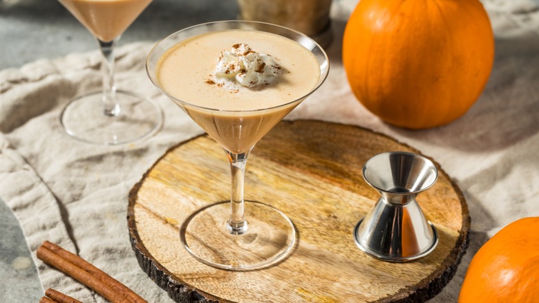 Pumpkin spice martini with pumpkins around it