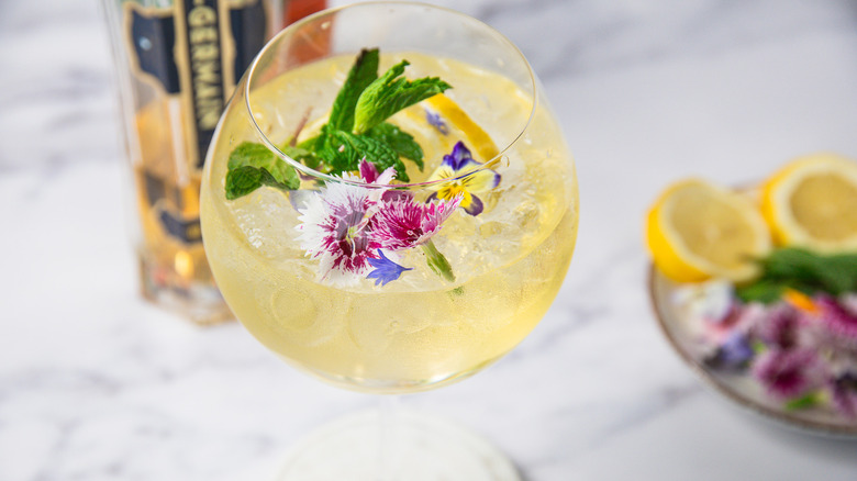 Springtime Hugo Spritz with mint, edible flowers and lemon slice