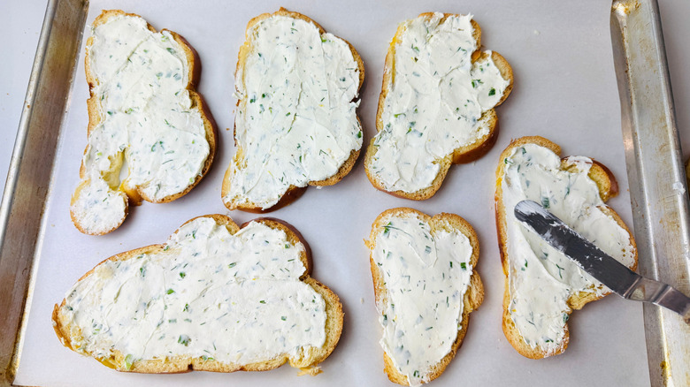 Slices of bread with herby cream cheese coating