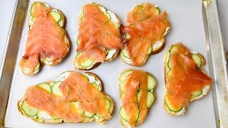 Slices of bread layered with cucumber and smoked salmon