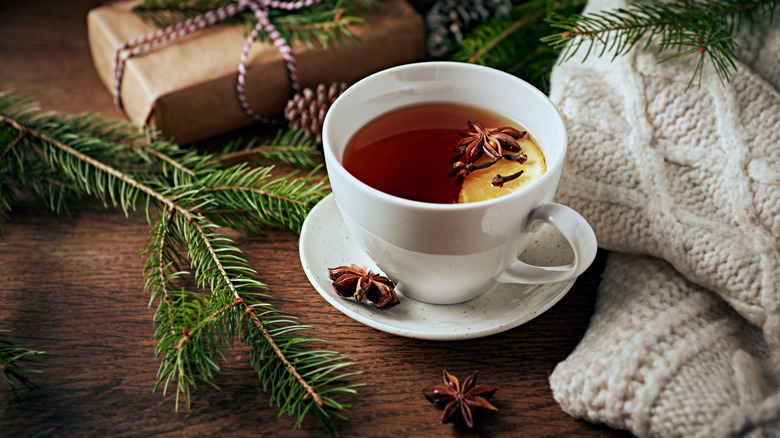 Cup of tea with pine branches, knit blanket