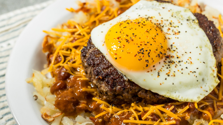 Close-up of a St. Louis slinger showing the hashbrown, chili, cheese, burger, and egg