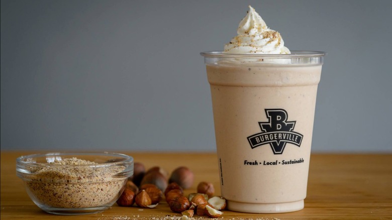 Burgerville Hazelnut Chocolate Milkshake next to ground hazelnuts