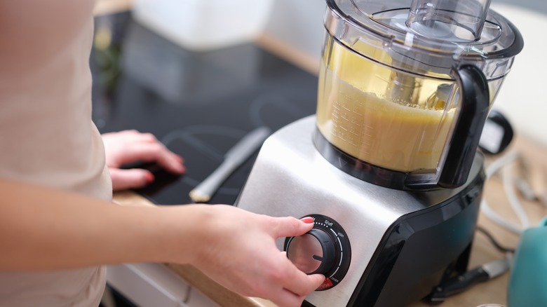 Woman adjusting speed of food processor