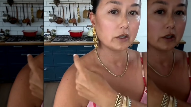 Corre Larkin of CocoLarkinCooks stands in her kitchen, gesturing at the stove and cookware behind her