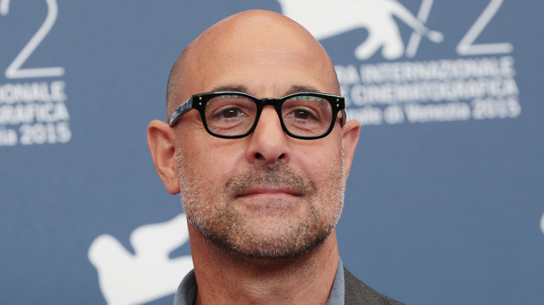 Stanley Tucci poses on a red carpet.