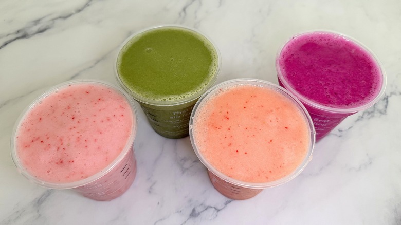Top-down shot of Starbucks drinks with lids off in zigzag formation on marble surface