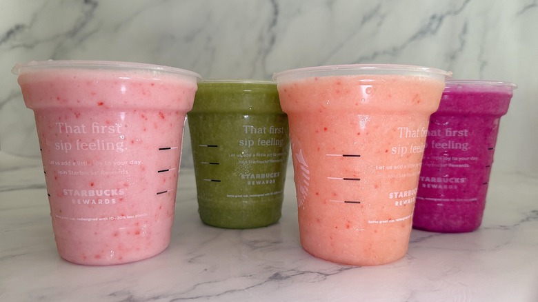Side shot of Starbucks drinks with lids off on marble surface