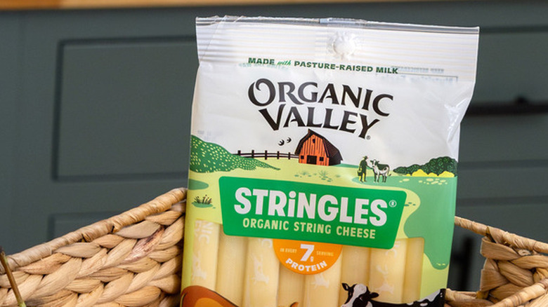 A packet of Organic Valley Stringles sticking out of a basket in a kitchen