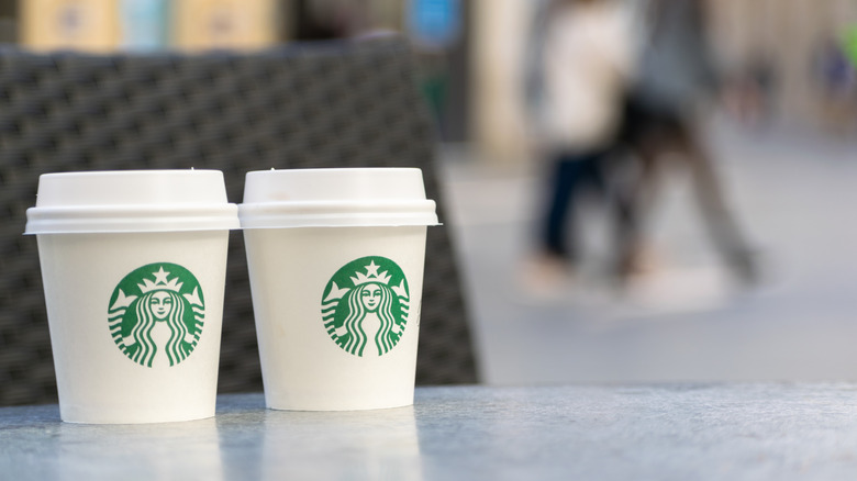 Two small Starbucks to go cups on a table