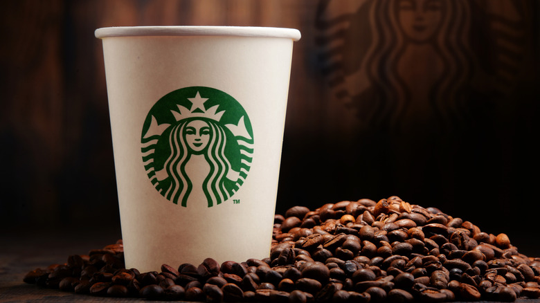 Starbucks hot cup sits on coffee beans 