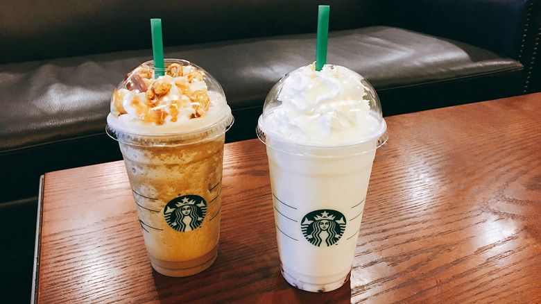 Two large Starbucks Frappuccinos, one caramel-based and one vanilla