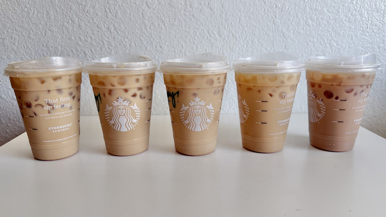 Five Starbucks iced latte drinks on a table