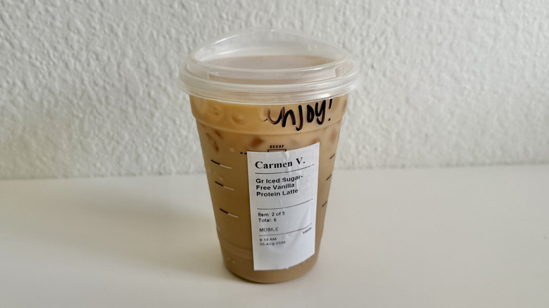 Sugar-free vanilla protein iced latte cup that says "enjoy!"