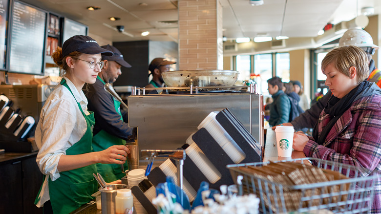 A Starbucks worker taking a customer's order