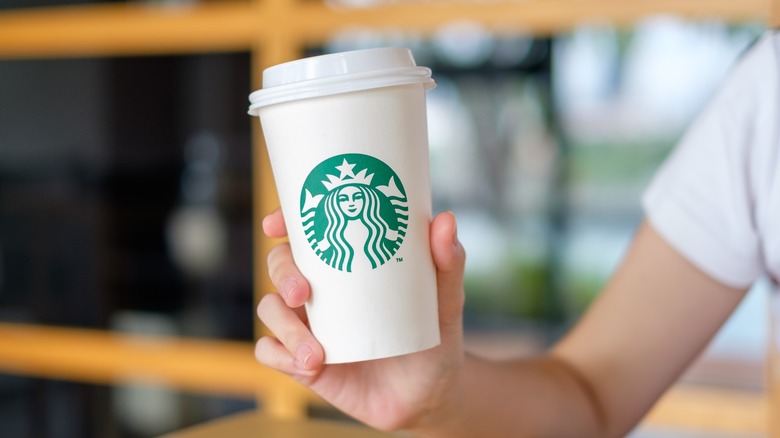 woman holding Starbucks coffee cup