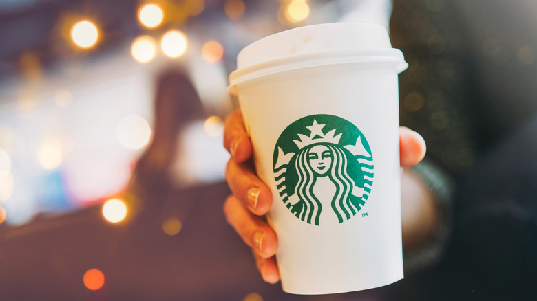 A person holds a Starbucks cup