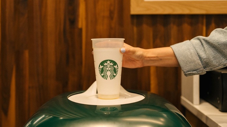 Place Starbucks cup in collection bin